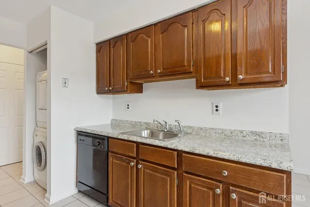 a kitchen with granite countertop stainless steel appliances wooden cabinets and a sink