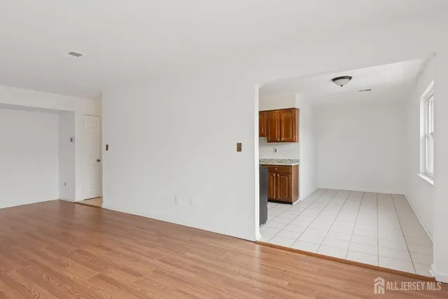 a view of a livingroom with wooden floor and a kitchen space