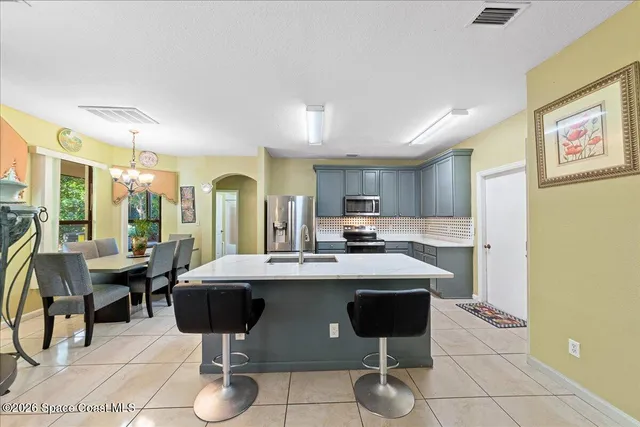 a kitchen with stainless steel appliances kitchen island granite countertop a sink and a refrigerator