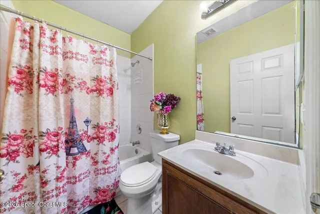 a view of a livingroom with a chandelier fan and a bathroom