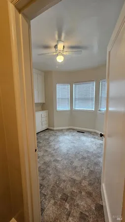 a view of empty room with window and ceiling fan