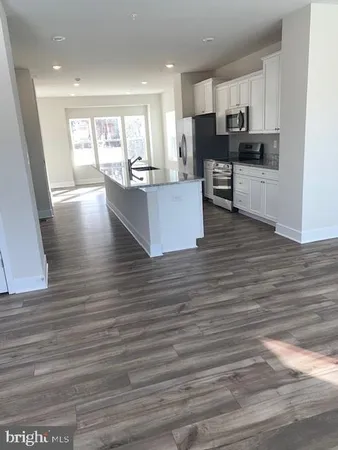 a large white kitchen with wooden floors and a fireplace