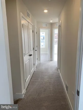 a view of a hallway with wooden shelves