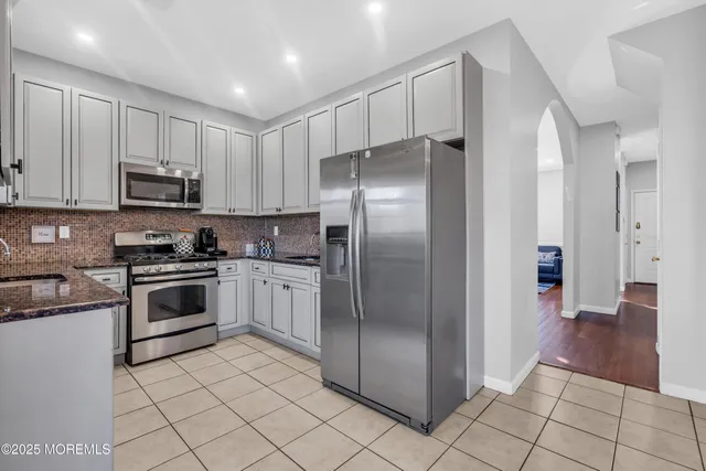 a kitchen with stainless steel appliances granite countertop a refrigerator and a stove top oven