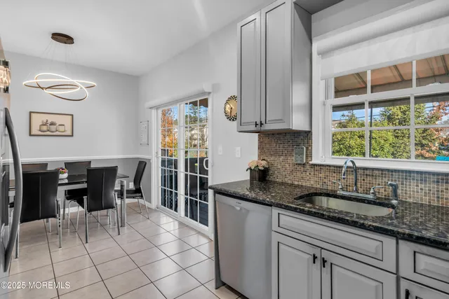 a kitchen with granite countertop a sink and a refrigerator