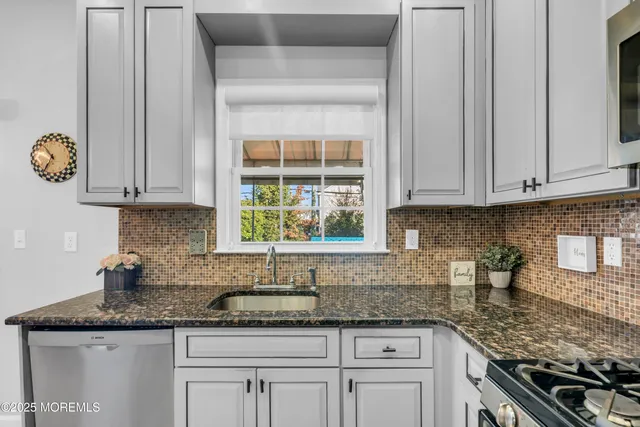a kitchen with granite countertop white cabinets and a stove