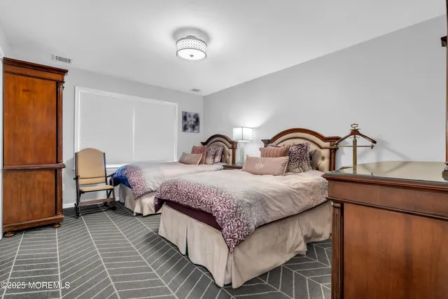 a bedroom with two beds and a dresser