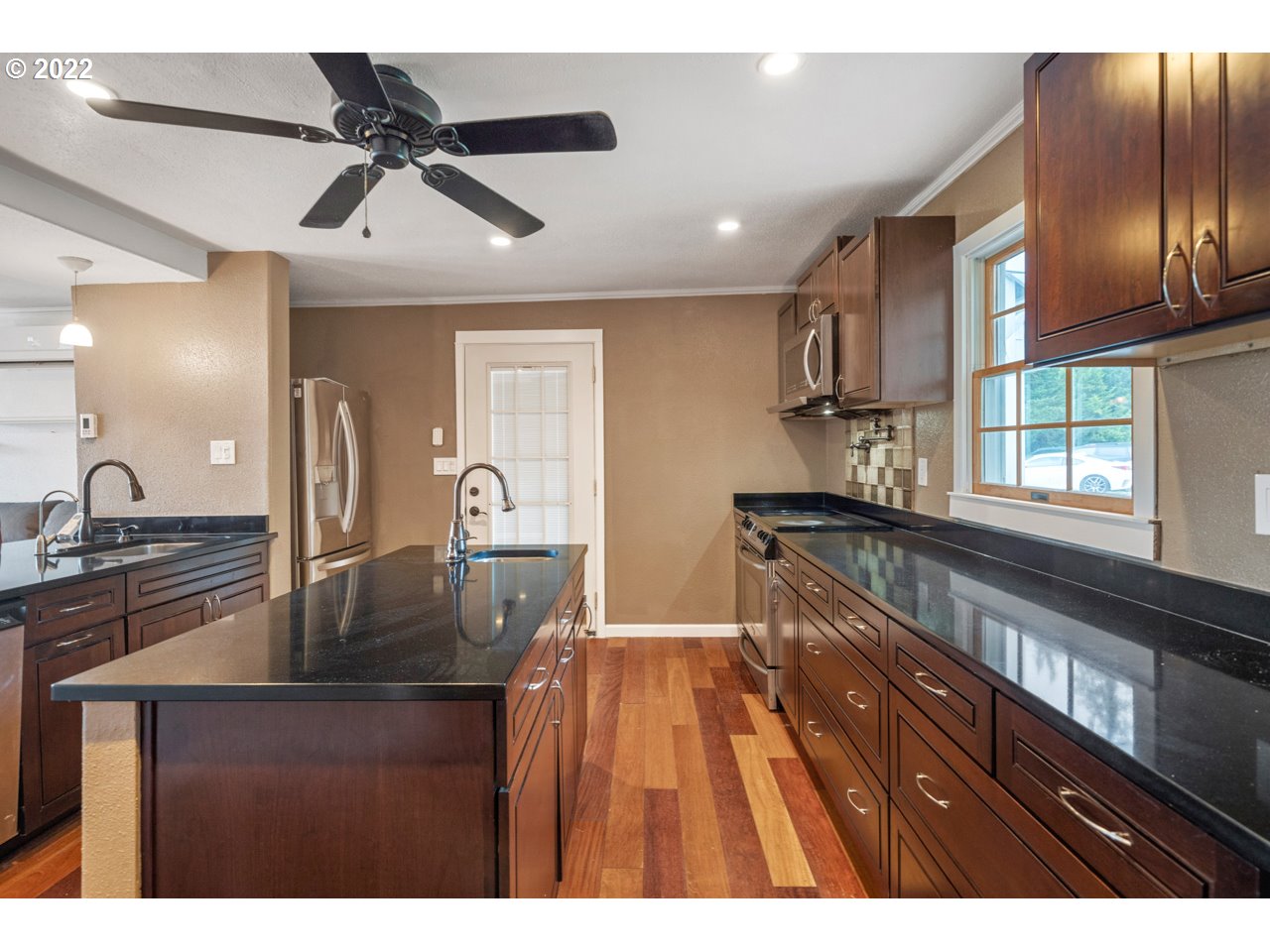 8480 Northeast Dog Ridge Road Newberg, OR 97132 - Photo 5 of 30 a kitchen view with granite countertop a refrigerator a sink a counter space and a dining table
