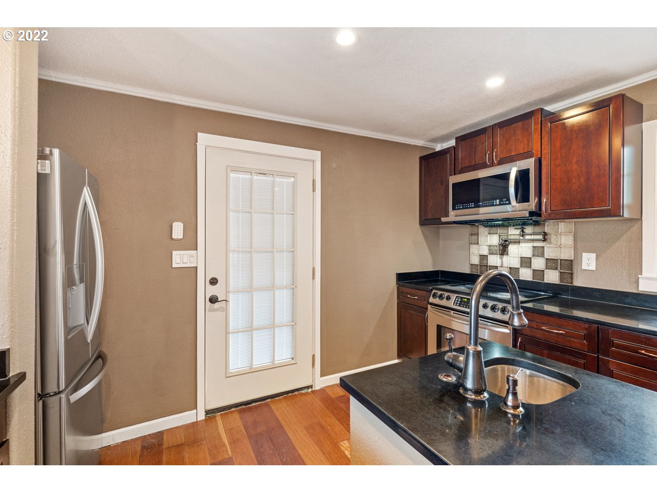 8480 Northeast Dog Ridge Road Newberg, OR 97132 - Photo 6 of 30 a kitchen with granite countertop a refrigerator and a sink