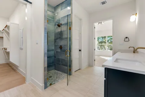 a bathroom with a shower sink and mirror