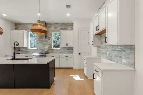 a kitchen with a sink stove and cabinets