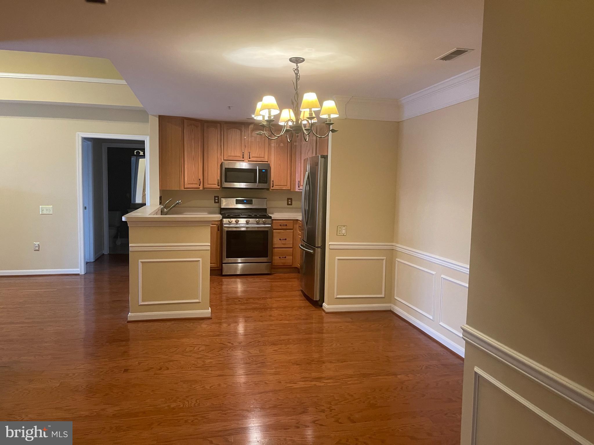 402 Aggies Circle, Unit L Bel Air, MD 21014 - Photo 3 of 23 a view of a kitchen with a stove wooden cabinets and a refrigerator
