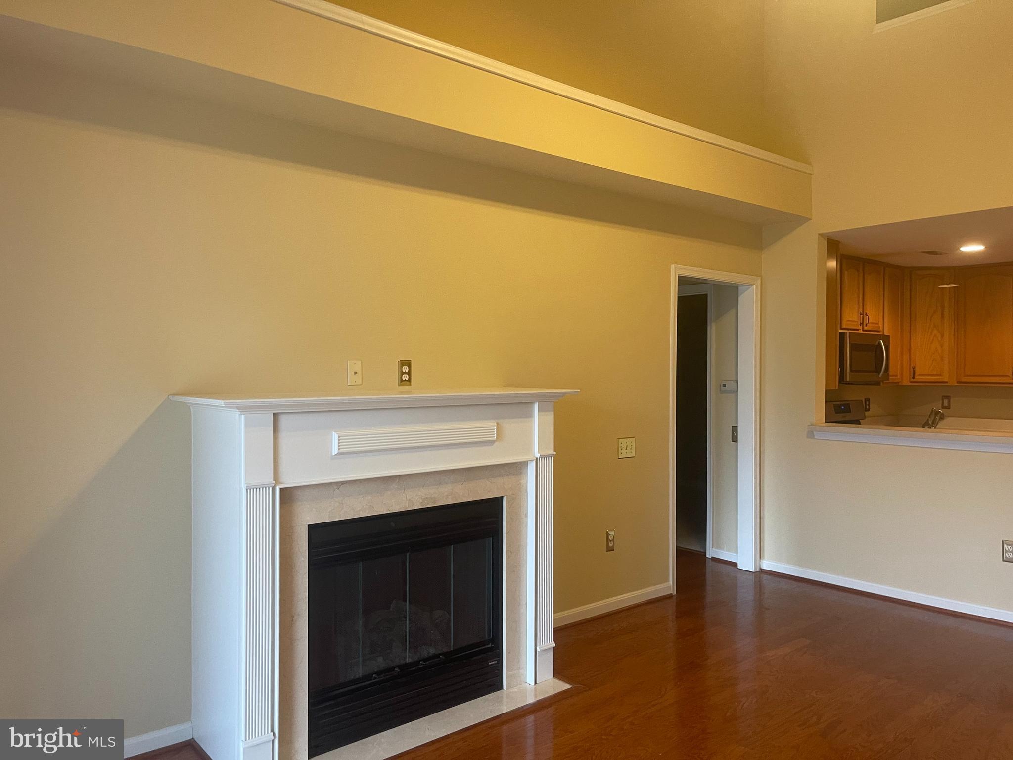 402 Aggies Circle, Unit L Bel Air, MD 21014 - Photo 8 of 23 a view of an empty room with wooden floor and a fireplace