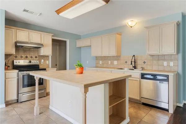 a kitchen with a sink a stove and cabinets