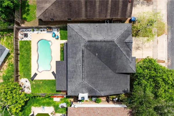 a aerial view of a house with a yard and potted plants