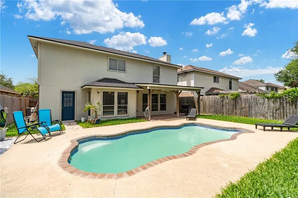 a view of a house with swimming pool and sitting area