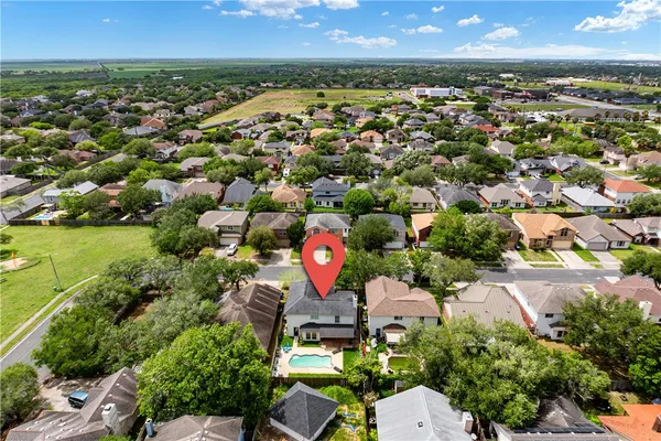 an aerial view of residential houses with outdoor space and trees