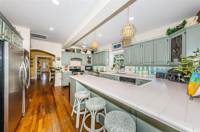 a kitchen with stainless steel appliances granite countertop a sink a stove and a refrigerator