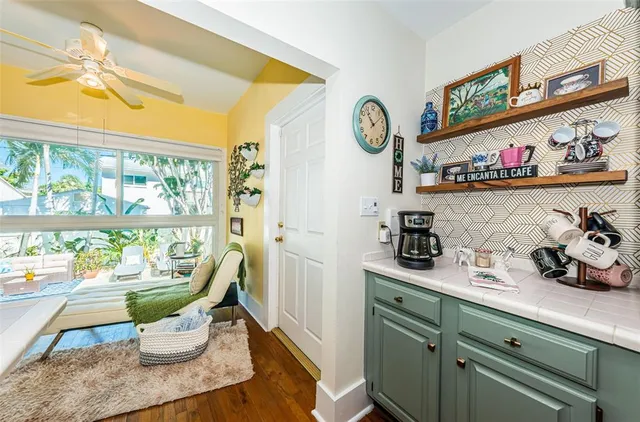 a room with stainless steel appliances a stove a sink and a large window with garden view