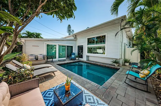 a view of a house with pool and sitting area