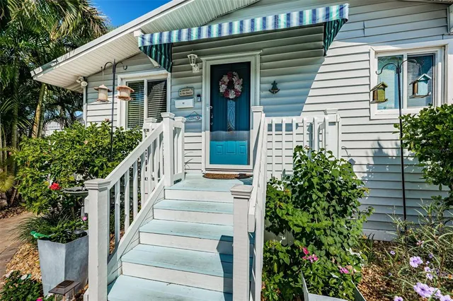 a view of a house with potted plants and a table and chair