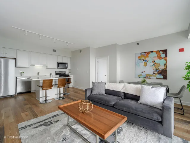 a living room with furniture kitchen view and a table
