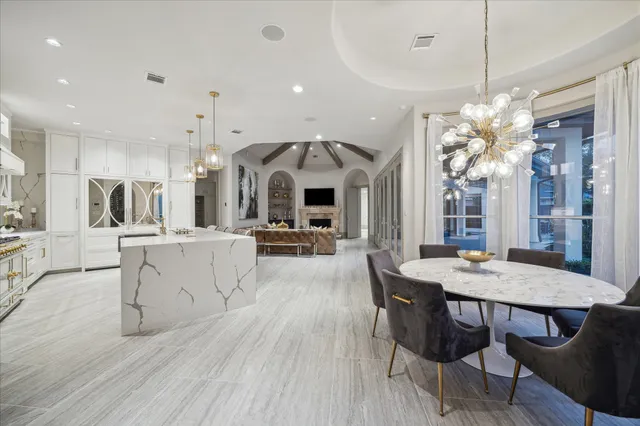 a view of a dining room and livingroom with furniture wooden floor a chandelier