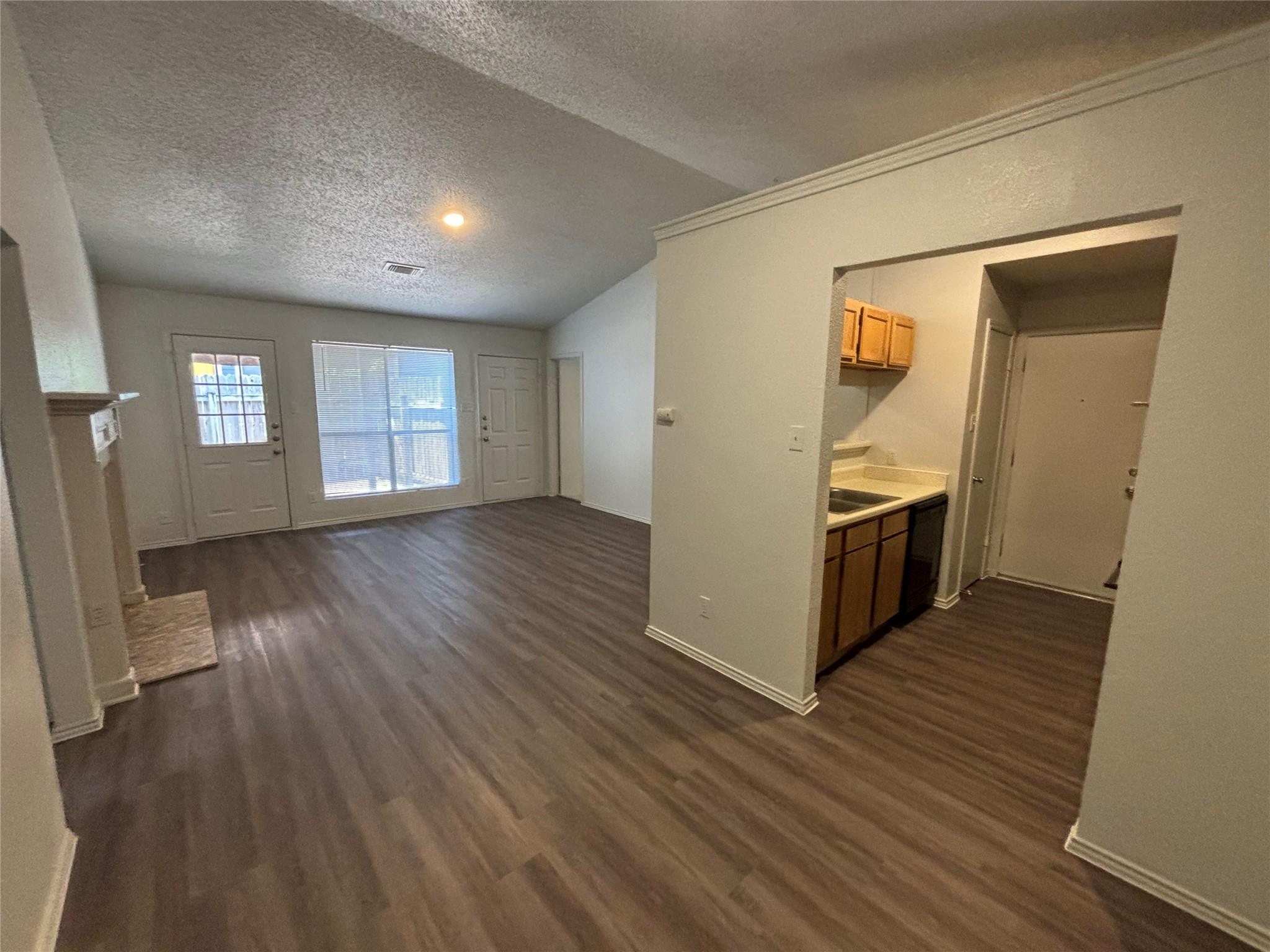 2033 Redwing Way Round Rock, TX 78664 - Photo 3 of 13 Spacious living area featuring wood-finish flooring, a vaulted ceiling, and a fireplace with a mantel