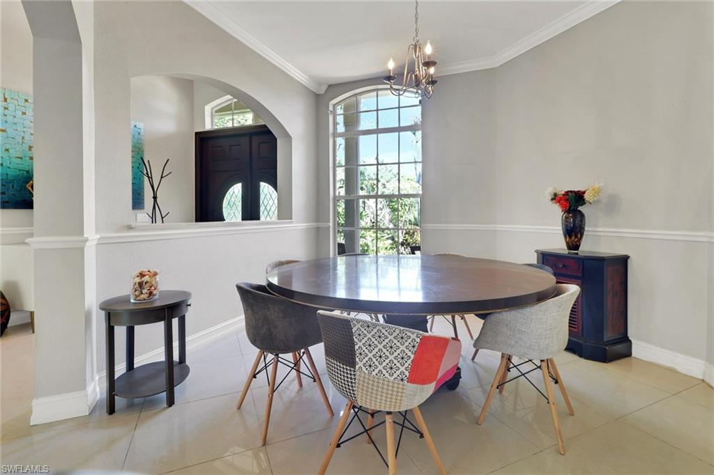 4380 7th Avenue Southwest Naples, FL 34119 - Photo 11 of 39 a view of a dining room with furniture and chandelier