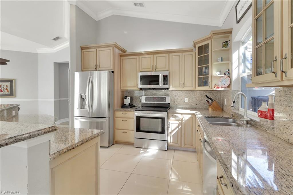 4380 7th Avenue Southwest Naples, FL 34119 - Photo 16 of 39 a kitchen with stainless steel appliances granite countertop a refrigerator and a stove top oven