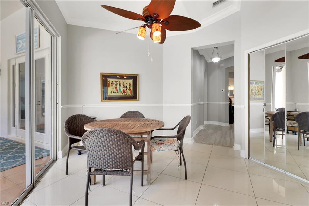 4380 7th Avenue Southwest Naples, FL 34119 - Photo 18 of 39 a view of a dining room with furniture and a chandelier fan