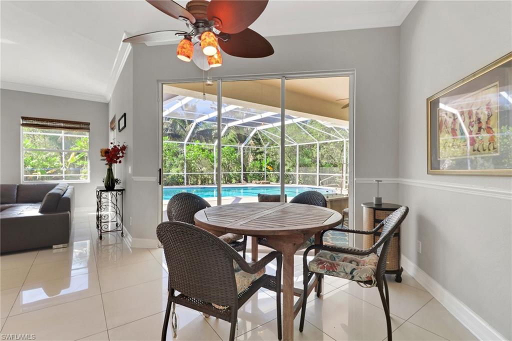 4380 7th Avenue Southwest Naples, FL 34119 - Photo 19 of 39 a dining room with furniture a chandelier and wooden floor