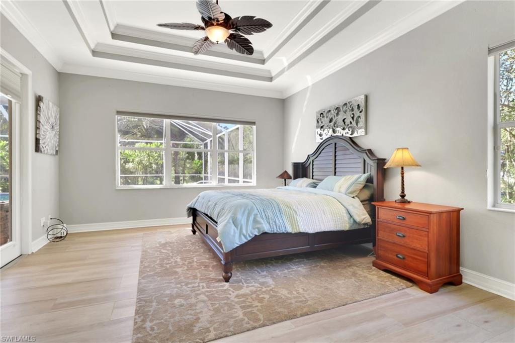 4380 7th Avenue Southwest Naples, FL 34119 - Photo 20 of 39 a bedroom with a bed and a chandelier