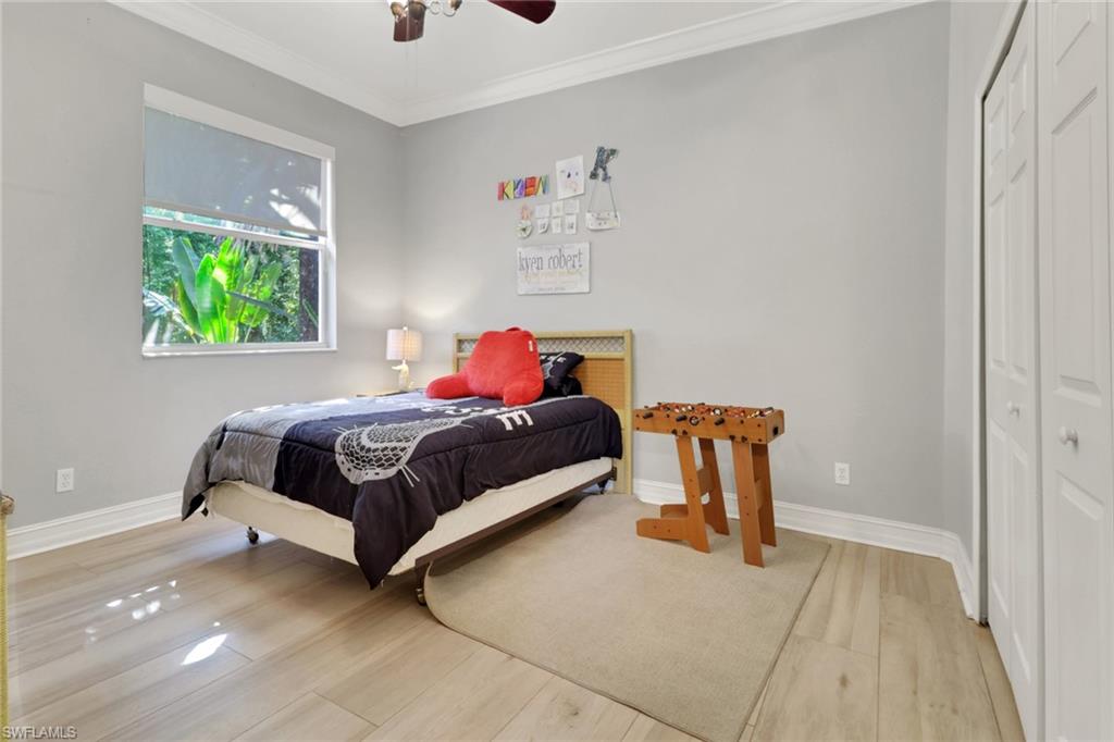 4380 7th Avenue Southwest Naples, FL 34119 - Photo 25 of 39 a bedroom with a bed and a chandelier