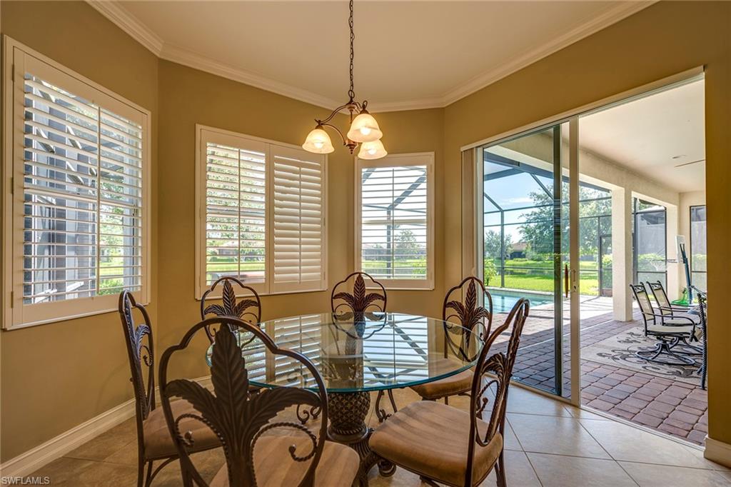 6065 Divot Court Naples, FL 34113 - Photo 4 of 18 a dining room with furniture a chandelier and wooden floor