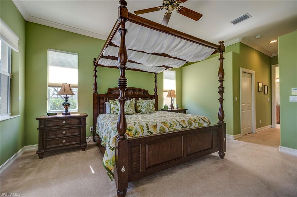 6065 Divot Court Naples, FL 34113 - Photo 7 of 18 a bedroom with a bed and a chandelier