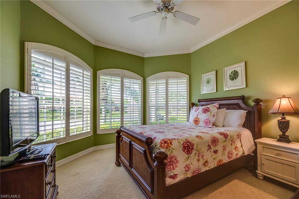 6065 Divot Court Naples, FL 34113 - Photo 9 of 18 a bedroom with a bed and a chandelier