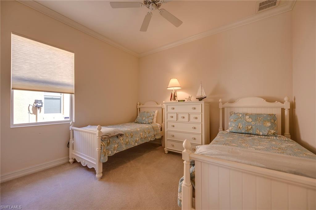 6065 Divot Court Naples, FL 34113 - Photo 10 of 18 a spacious bedroom with a bed and a chandelier