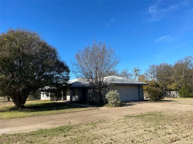 a front view of a house with a yard and trees