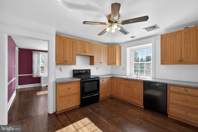 a kitchen with stainless steel appliances granite countertop a stove cabinets and wooden floor