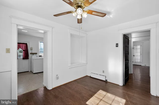a view of a room with wooden floor and a ceiling fan