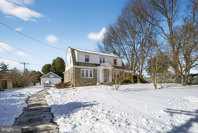 a front view of a house with a yard covered in snow
