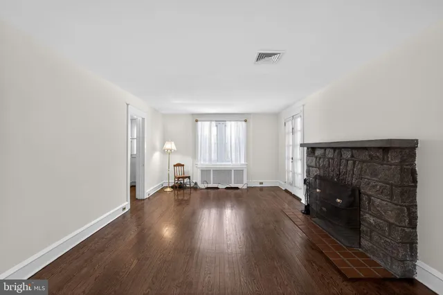 an empty room with wooden floor and fireplace