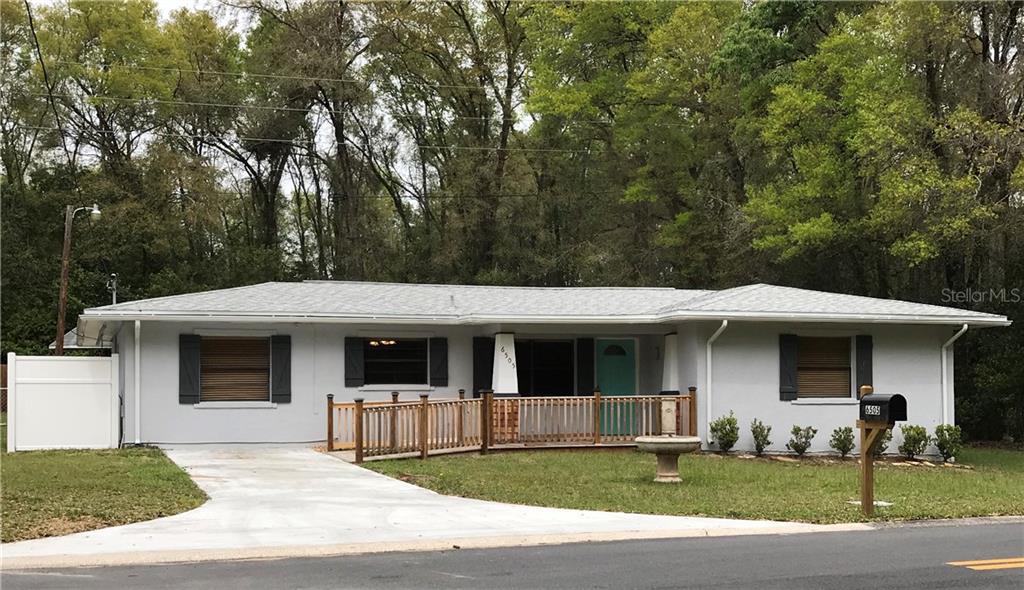 6505 East Amity Street Inverness, FL 34452 - Photo 1 of 1 a view of a white house with large windows and a large tree