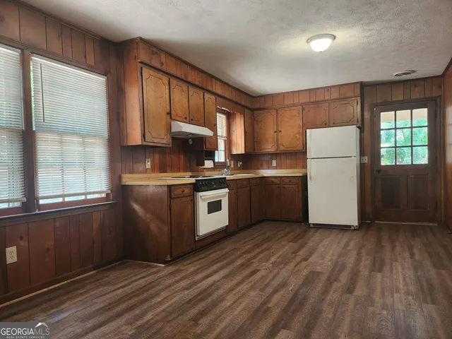 a kitchen with a refrigerator a stove top oven and a window