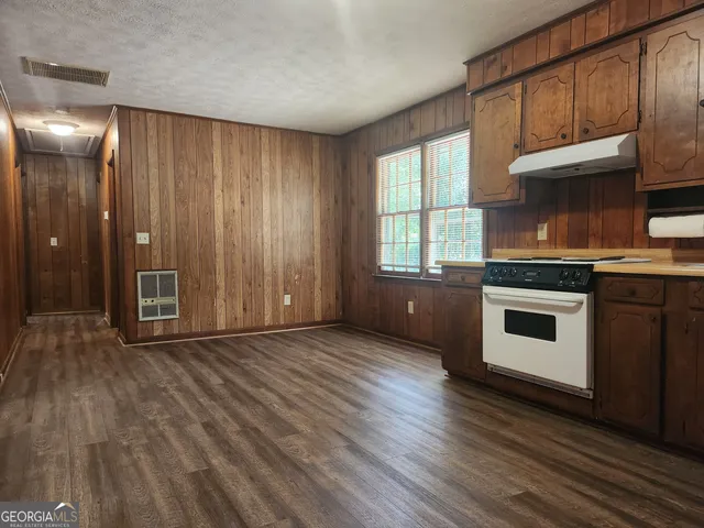 a kitchen with granite countertop wooden floors and wide window