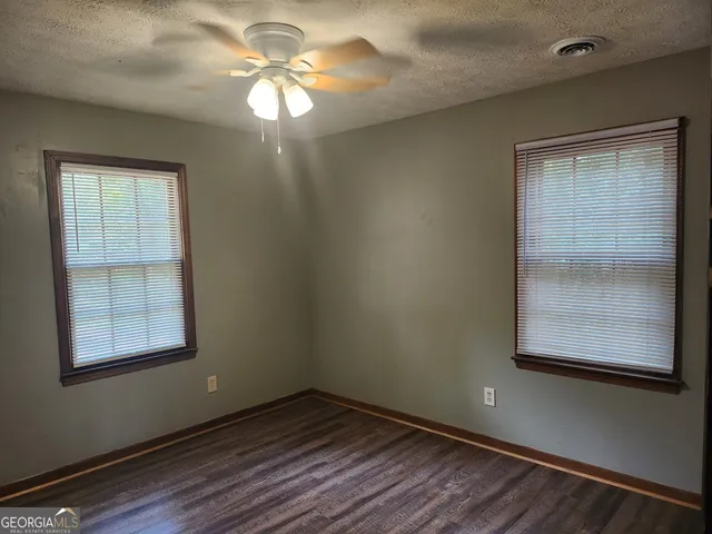 an empty room with windows and closet