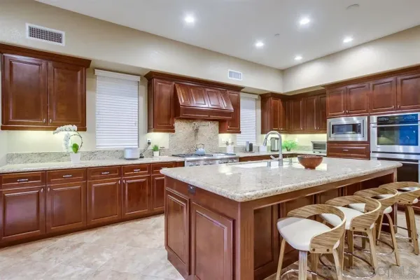 a living room with fireplace furniture and a kitchen view
