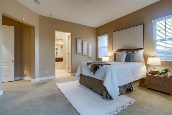 a spacious en suite bathroom with a granite countertop double vanity sink and a mirror