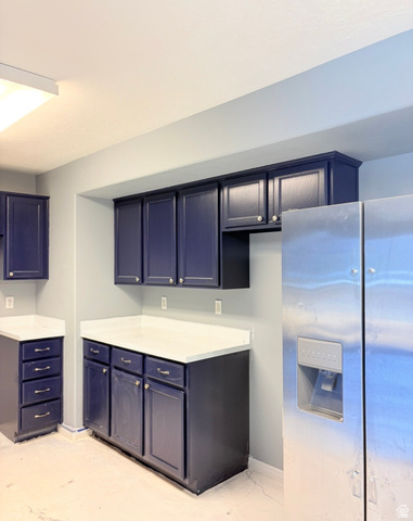 8116 North Ridge Loop West, Unit 8 Eagle Mountain, UT 84005 - Photo 5 of 23 Kitchen featuring stainless steel refrigerator with ice dispenser, light countertops, and blue cabinets
